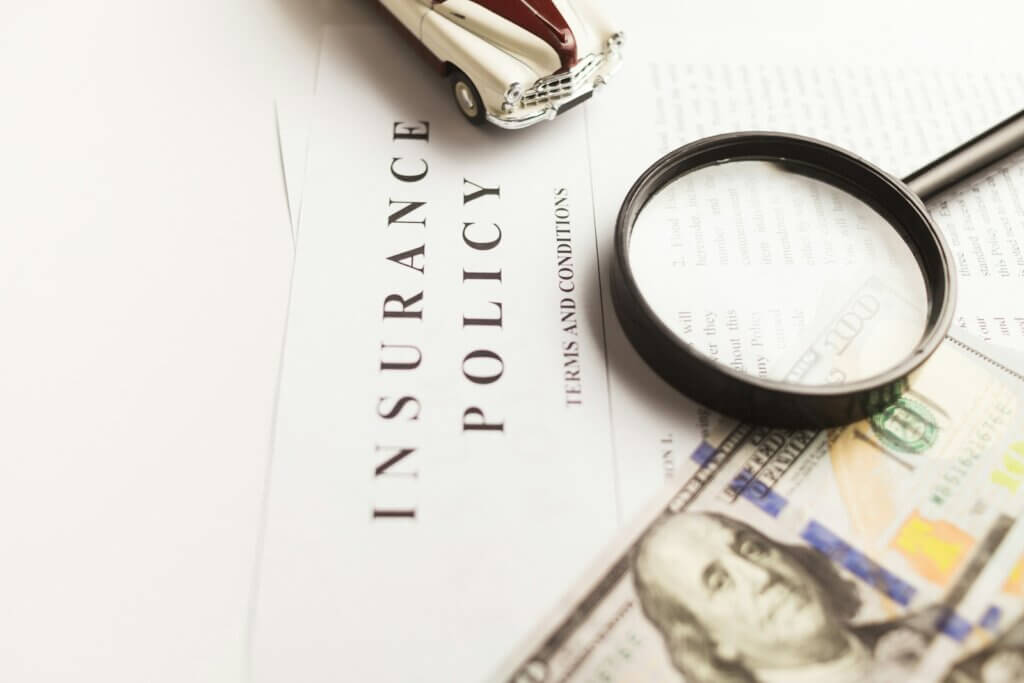 a magnifying glass sitting on top of an insurance policy paper