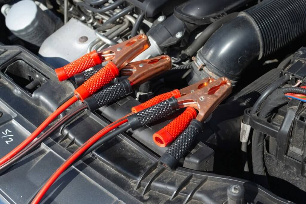 red and black jumper cables connected to car engine